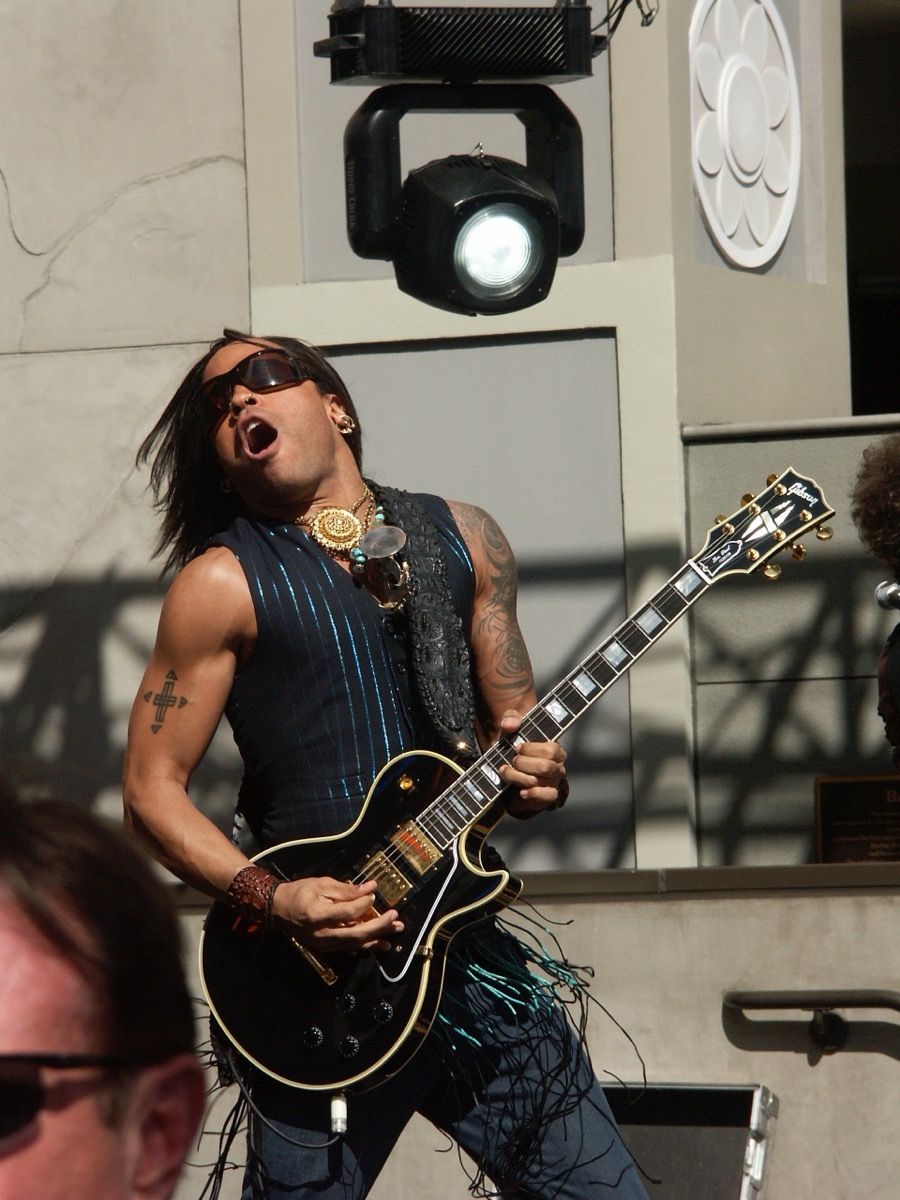 Lenny Kravitz wearing black vest and pendant necklace at Hollywood & Highland