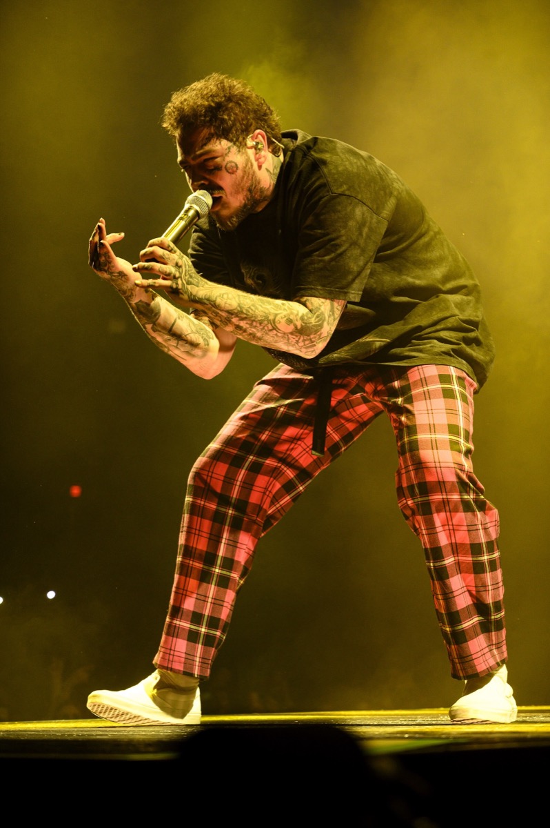 Post Malone wearing red plaid trousers and black t-shirt at Runaway Tour